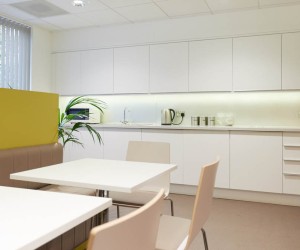 white office kitchen with breakout tables and chairs