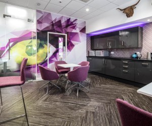 modern office kitchen in grey with breakout area with high table and stools, breakout benches and chairs
